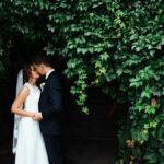 beautiful young wedding couple kissing , blonde bride with flowe