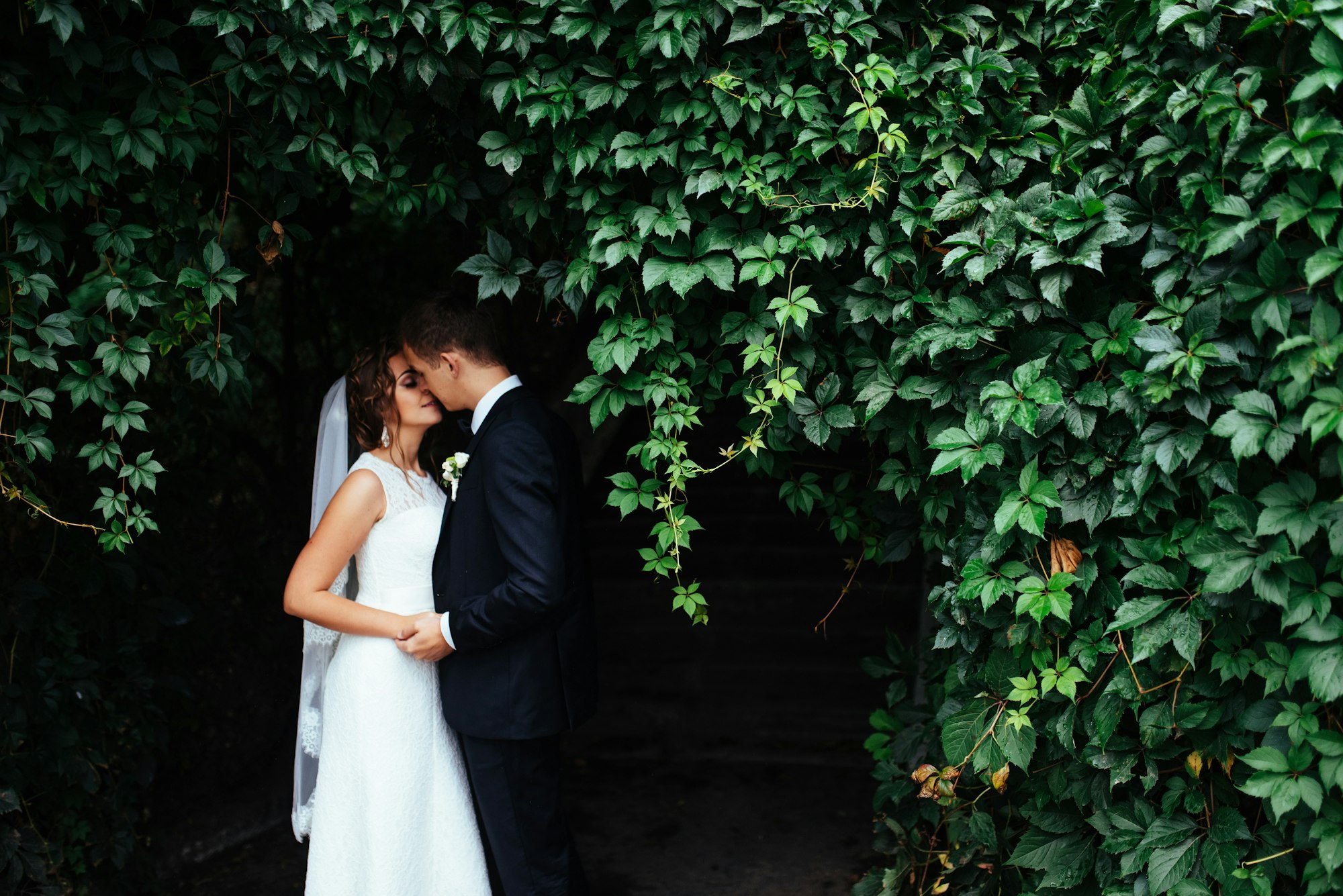 beautiful young wedding couple kissing , blonde bride with flowe