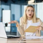 Businesswoman confused by bad news in an envelop