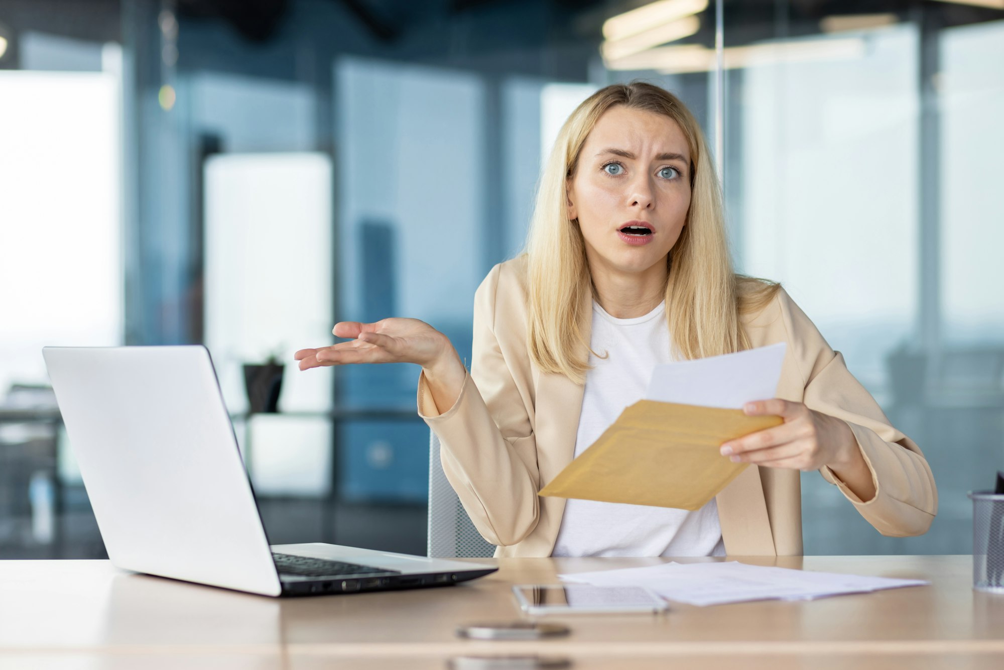 Businesswoman confused by bad news in an envelop