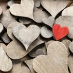 Wooden hearts, one red heart on the heart background.